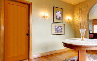 Interior wood door, framed art, and round marble table